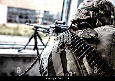 Rückansicht eines Machine gunner Feuern durch ein Fenster in eine Ruine. Stockfoto
