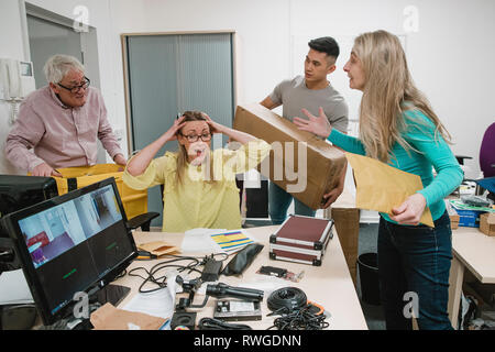 Reife Frau wird am Arbeitsplatz durch Kollegen an ihrem Geschrei verrückt. Stockfoto