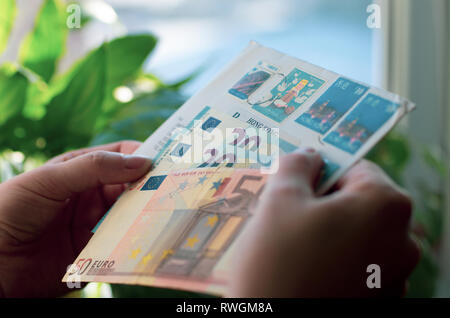 In Frauenhand einen Umschlag mit Briefmarken von Hong Kong und Euro-banknoten Stockfoto
