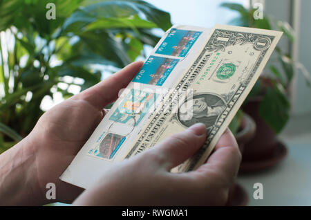 In Frauenhand einen Umschlag mit Briefmarken von Hong Kong und Dollar Banknote Stockfoto