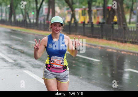 DNIPRO, UKRAINE - September 16, 2018: Positive junge Frau läuft auf Dnipro Stadt Straße in 42 km Entfernung von ATB Dnipro Marathon Stockfoto