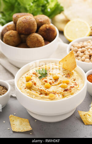 Traditionelle hausgemachte und Falafel und Hummus Kichererbsen serviert mit Pita, Chips und Gewürzen. Stockfoto