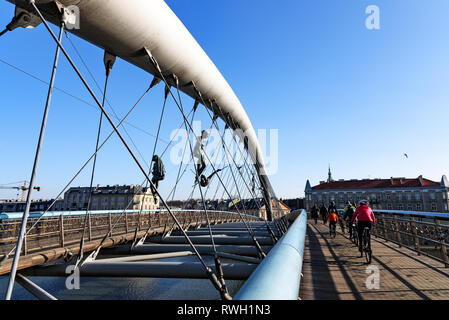 Krakau, Polen - 16. Februar 2019: die Menschen gehen durch die berühmte Brücke von Vater Bernatka auf der Weichsel in Krakau an einem sonnigen Tag. Die fo Stockfoto