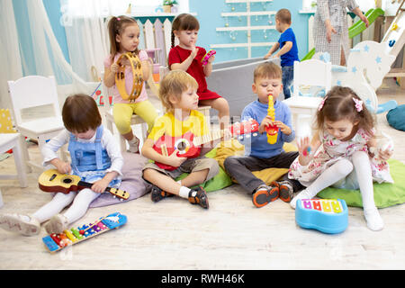 Kinder lernen Musikinstrumente auf Lektion im Kindergarten oder in der Vorschule Stockfoto