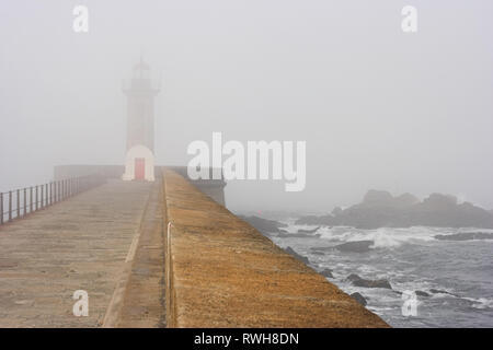 Alter kleiner Leuchtturm an der Mündung des Flusses Douro in Porto (Portugal) in einem nebligen Tag Stockfoto