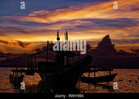 Apo Island, Philippinen. 6. Mai, 2018. Tropischen Sonnenuntergang mit Boot auf Apo Island, Philippinen. Quelle: Bernard Menigault/Alamy Stock Foto Stockfoto