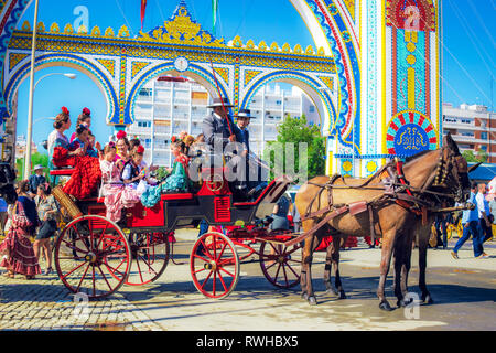 Spanische Familien in traditionellen und farbenfrohen Kleid in einem Pferd reisen Kutschen im April Messe, Stockfoto