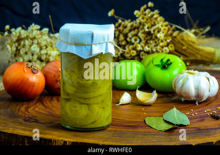 Erhaltene vegetarisches Essen Konzept. Dosen grüne Zwiebel in einem Glas auf Holz- Hintergrund. Stockfoto