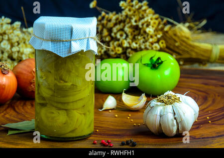 Erhaltene vegetarisches Essen Konzept. Dosen grüne Zwiebel in einem Glas auf Holz- Hintergrund. Stockfoto