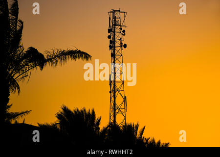 Silhouette der Telekommunikation Antenne Funkmast für mobile Signal Netzwerk mit schönen Sonnenuntergang Himmel Hintergrund Stockfoto