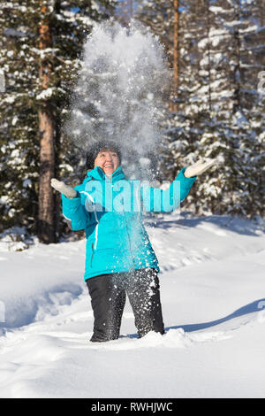 Neryungry Nerungry, Bezirk, Jakutien, Russland. Februar 5, 2017 Frau wirft Schnee im Winter Wald Stockfoto