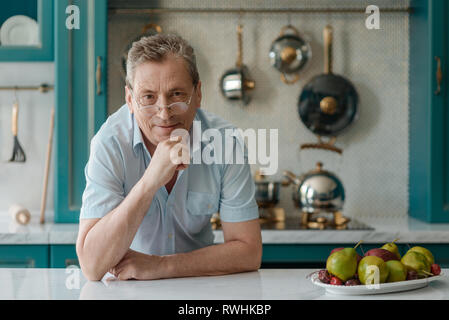 Alter Mann am Tisch sitzen Stockfoto