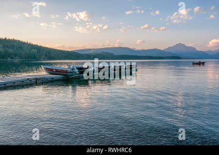 Boote auf dem Steg an einem ruhigen Abend am See in Apgar auf Lake McDonald im Glacier National Park, Montana, USA Stockfoto