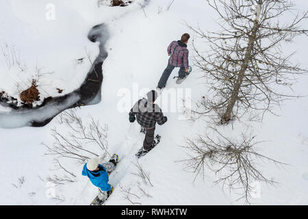 Eine Gruppe von Freunden (alle Ende 30) Schneeschuhwandern entlang einem Bach im Winter. Mont Tremblant, Quebec, Kanada Stockfoto