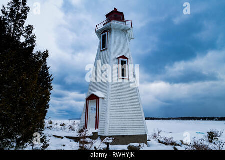 Leuchtturm steht wie ein einsamer Sentinel gegen eine kalte, winterliche Georgian Bay, Bruce Peninsula National Park, Tobermory, Ontario, Kanada Stockfoto