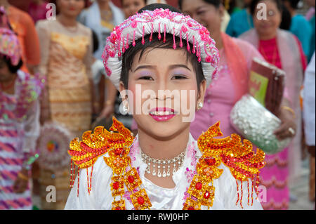 Das Porträt eines jungen Burmesen, der in buddhistischer Tracht gekleidet ist und sich mit Makeup ausstellte, besucht seine Zeremonie im Alter in Mandalay Myanmar Stockfoto