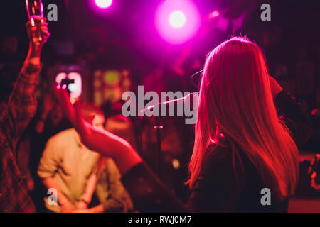 Unterhaltungsprogramm bei einer Hochzeit. Eine Sängerin ist die Interaktion mit dem Publikum, während ein Mann, eine akustische Gitarre spielt. Stockfoto