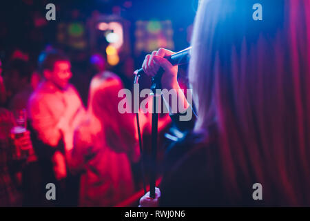 Unterhaltungsprogramm bei einer Hochzeit. Eine Sängerin ist die Interaktion mit dem Publikum, während ein Mann, eine akustische Gitarre spielt. Stockfoto