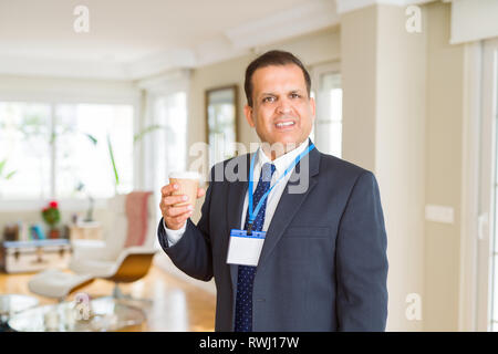 Mittleres Alter Geschäftsmann, trinken eine Tasse Kaffee tragen ID-Karte Stockfoto