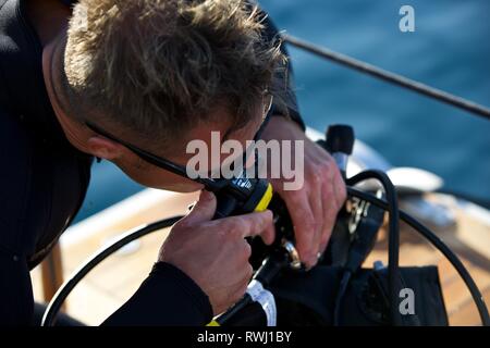 Nahaufnahme von Diver Kontrolle atemschutzmaske an Bord Boot Deck Stockfoto