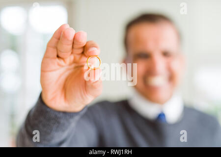 Nahaufnahme des mittleren alter Mann hält einen Verlobungsring und lächelnd in die Kamera Stockfoto