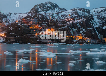 Mit Blick über die engen Hafen von St. John im Winter, das malerische Fischerdorf bekannt als die Batterie im Hintergrund. St. John's, Neufundland und Labrador Stockfoto