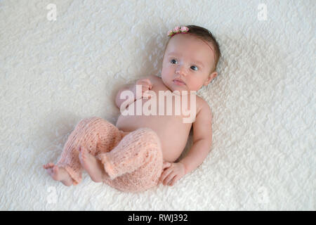 Porträt einer Warnung, einen Monat alt, Baby Mädchen aus Gewirken tragen, blass rosa Hose. Stockfoto