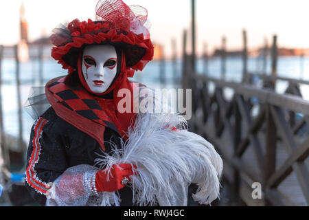 Venezianische Masken Modell aus der Karneval von Venedig 2019 mit Gondeln im Hintergrund Stockfoto