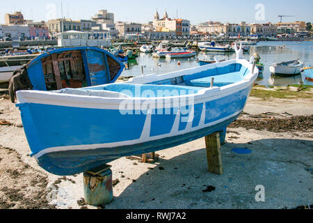 Schöne alte Angeln Boote aus Holz, weiß und blau gefärbt, mit Altstadt auf Hintergrund in Bari, Apulien, Italien Stockfoto