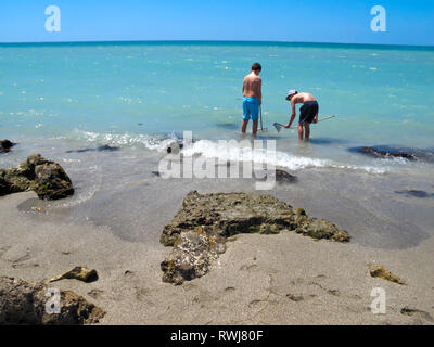 2 jugendlich Jungen, auf der Suche nach Zähne Haie'; Metall Körbe; große Felsen; aqua Wasser, Golf von Mexiko; Caspersen Beach; Venedig; FL; Florida; Horizontal; HERR Stockfoto