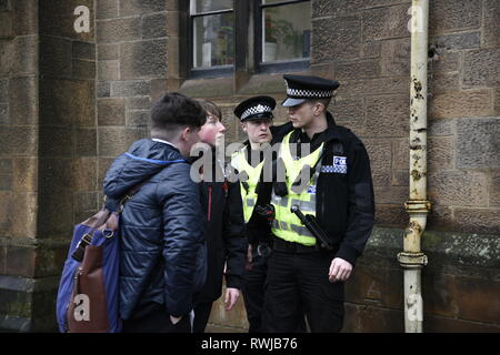 Glasgow, Glasgow, UK. 6 Mär, 2019. Zwei Studenten gesehen Sprechen mit Polizisten über die Lage. Die Polizei hat ein verdächtiges Paket an der Universität Glasgow in Schottland gefunden. Polizei und Campus Mitarbeiter haben den Bereich abgeschaltet. Credit: Stewart Kirby/SOPA Images/ZUMA Draht/Alamy leben Nachrichten Stockfoto