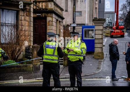 Glasgow, Glasgow, UK. 6 Mär, 2019. Polizisten gesehen sprechen und gleichzeitig eine strassensperre an der Cordon. Die Polizei ein verdächtiges Paket an der Universität Glasgow in Schottland gefunden haben. Polizei und Campus Mitarbeiter haben den Bereich abgeschaltet. Credit: Stewart Kirby/SOPA Images/ZUMA Draht/Alamy leben Nachrichten Stockfoto