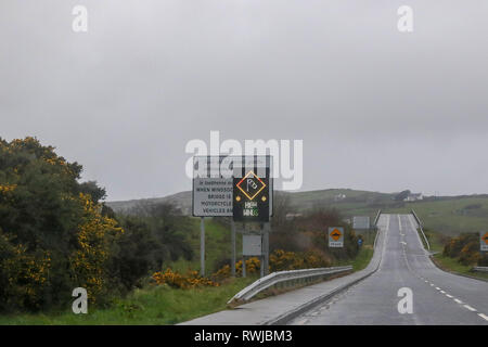 County Donegal, Irland. 06. März 2019. Irland Wetter - nach schweren nächtlichen Regen war es ein Tag der starken Winde und Regen in County Donegal. Starke Winde Warnschild am Harry Blaney Brücke, wie aus dem Inneren eines Autos gesehen. Quelle: David Hunter/Alamy Leben Nachrichten. Stockfoto