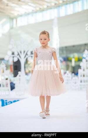 Kiew, Ukraine März 03.2019. UKFW. Ukrainische Kids Fashion Tag. Kleines Mädchen auf pastellfarbene Kleid tragen am Podium posing Stockfoto