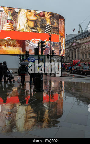 Piccadilly Circus, London im Regen mit den Reflexionen auf den Gehwegen Stockfoto