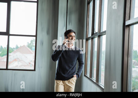Selbstbewussten jungen Geschäftsmann mit Mobiltelefon Stockfoto
