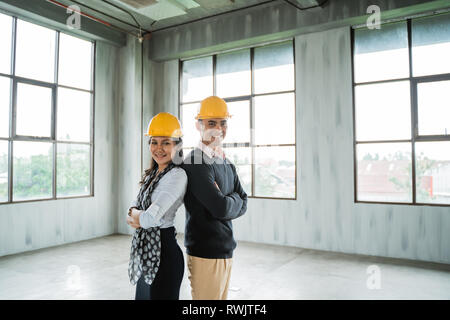 Ingenieur Team zurück zu gefalteten Händen zurück in die Halle mit einem Sicherheitshelm Stockfoto