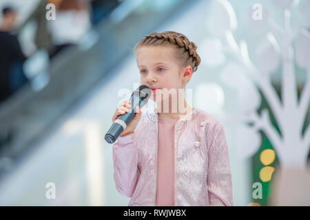 Kiew, Ukraine März 03.2019. UKFW. Ukrainische Kids Fashion Tag. Mädchen hält das Mikrofon in der Hand, während der Song bei einem Konzert Stockfoto