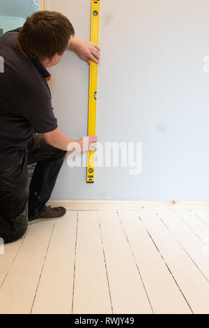 Workman Sockelleiste für die Ebenheit prüfen Stockfoto