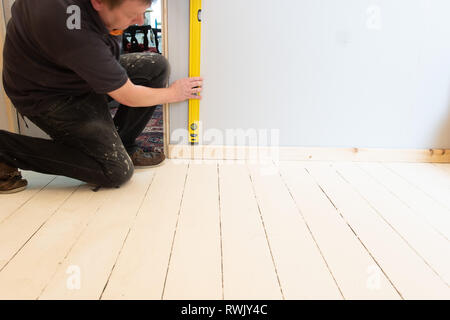 Workman Sockelleiste für die Ebenheit prüfen Stockfoto