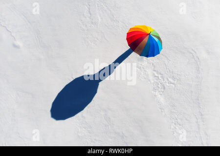 Jemand unter Regenbogenfarbenen auf weißem Schnee. Ansicht von oben Stockfoto