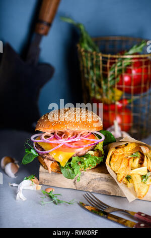 Nahaufnahme der Hausgemachte leckere Burger mit gebratenen Kartoffeln. Classic Cheeseburger. Stockfoto