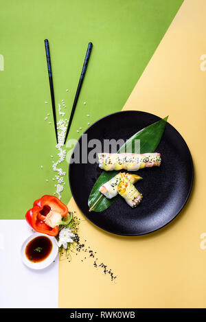 Frische asiatische Frühlingsrollen mit Garnelen und Gemüse und Früchten in einem Reis Papier gewickelt. Ansicht von oben, flach Stockfoto