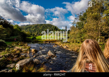 Touristen anschauen St. Kevin's Church und runder Turm in der Ferne bei Glendalough; im County Wicklow, Irland Stockfoto