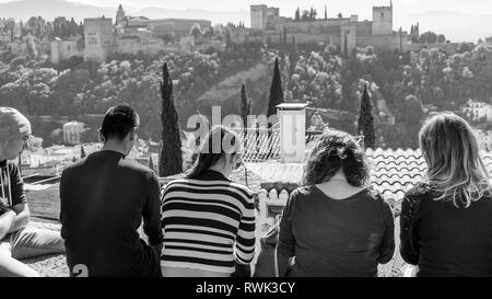 Touristen sitzen mit Blick auf die Alhambra, Granada, Andalusien, Spanien Stockfoto