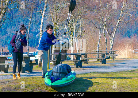 Jungen asiatischen Paar mit ihrem Schlauchboot Kajak und Paddel im Picknickbereich von Grant verengt Regional Park, B.C., Kanada Stockfoto