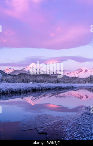 Alpenglow-Farben die schneebedeckten Berge der Küstenkette, der Mendenhall-Gletscher und die Mendenhall-Türme spiegeln sich im offenen Wasser entlang des Randes... Stockfoto