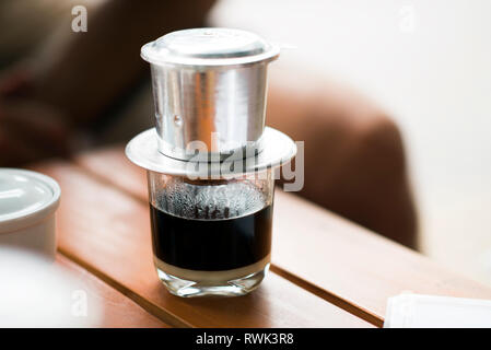 Vietnamesischen Kaffee - heiße Milch Kaffee mit Kondensmilch in Vietnam Stil. Traditionelle vietnamesische Trinken Stockfoto