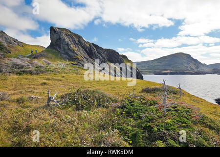 Zwei Wanderer inmitten von Felsen, Trout River Bay und die Berge in der Ferne wie aus den östlichen Punkt Trail im Fluss Forellen, Neufundland, Kanada gesehen Stockfoto