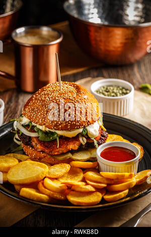 Handwerk Beef Burger und Pommes frites serviert mit Tomatensauce. Stockfoto